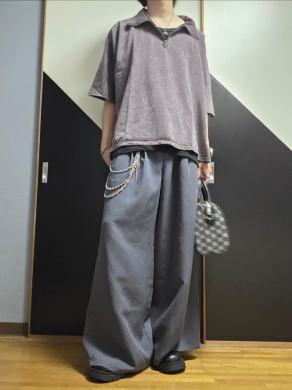 グレー系のスラックス、ブラック系のショルダーバッグ、ブラウン系のTシャツ/カットソーを着用したメンズの夏コーディネートの2枚目の写真