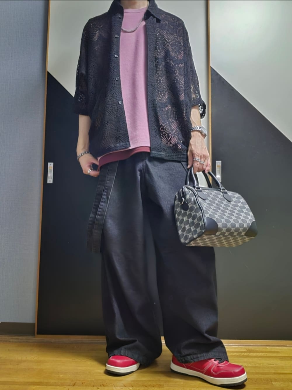 ブラック系のデニムパンツ、ブラック系のショルダーバッグ、レッド系のタンクトップを着用したメンズの夏コーディネートの2枚目の写真