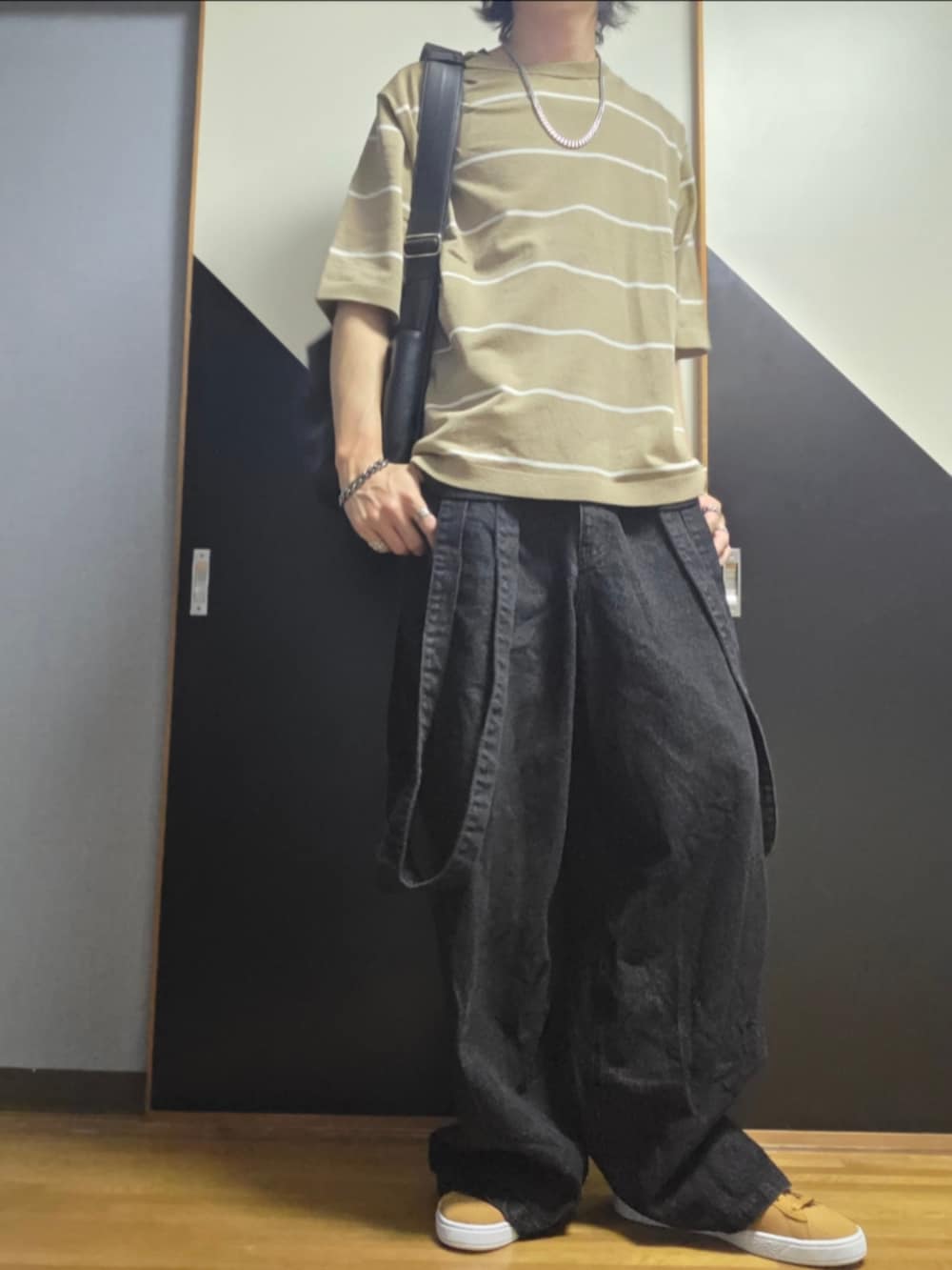 ブラウン系のスニーカー、ブラック系のデニムパンツ、ブラック系のタンクトップを着用したメンズの夏コーディネートの2枚目の写真