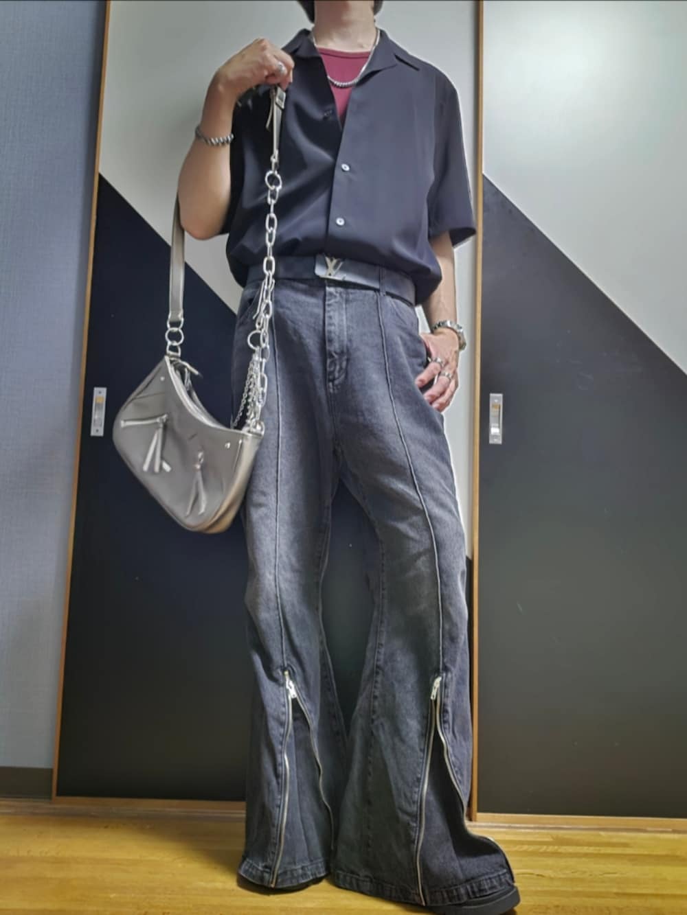 グレー系のデニムパンツ、シルバー系のショルダーバッグ、ブラック系のシャツ/ブラウスを着用したメンズの夏コーディネートの2枚目の写真