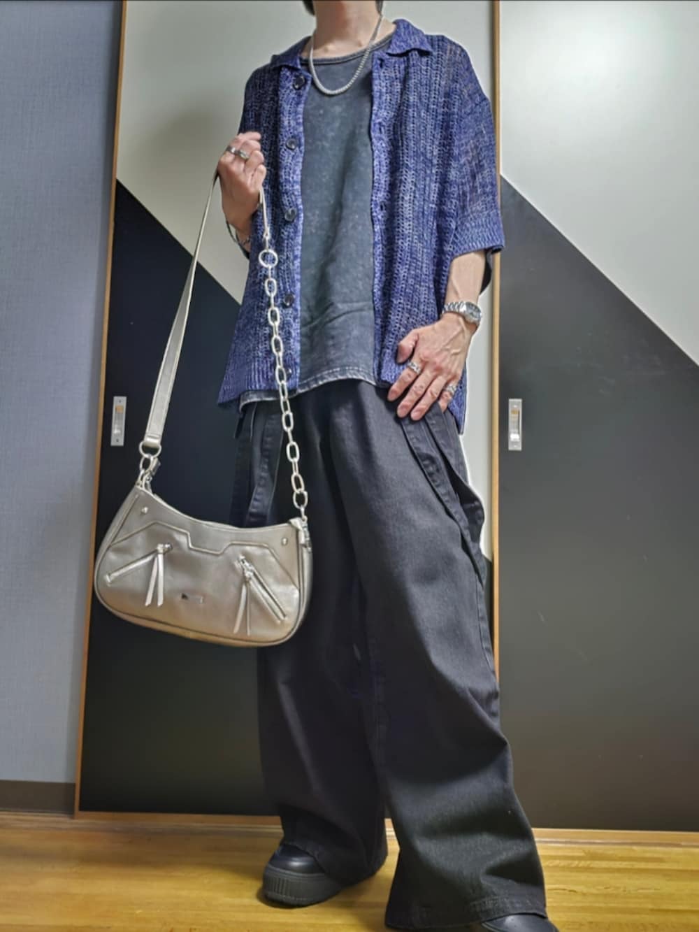 ブラック系のデニムパンツ、ブラック系のタンクトップ、ブルー系のカーディガン/ボレロを着用したメンズの春コーディネートの2枚目の写真
