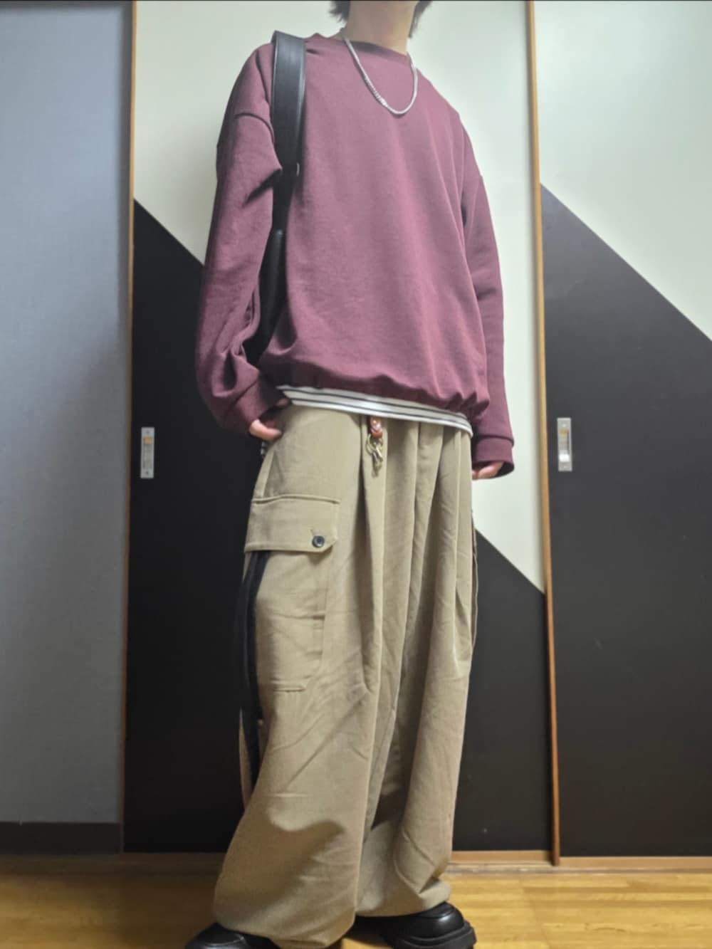 ベージュ系のカーゴパンツ、ブラック系のローファー、ホワイト系のタンクトップを着用したメンズの秋コーディネートの2枚目の写真