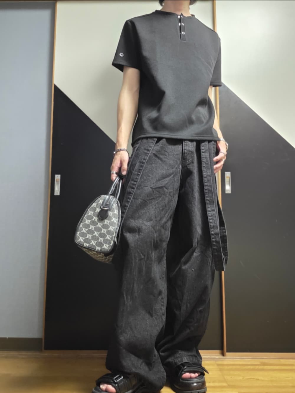 ブラック系のサンダル、ブラック系のデニムパンツ、ブラック系のショルダーバッグを着用したメンズの夏コーディネートの2枚目の写真