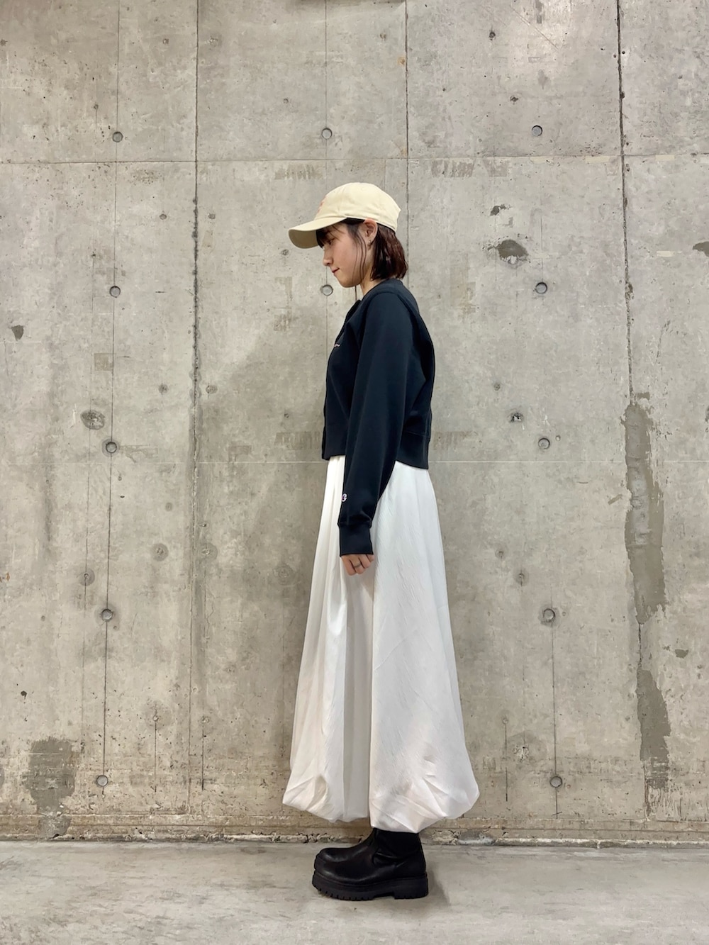 ブルー系のカーディガン/ボレロ、ブラック系のブーツ、ホワイト系のスカートを着用したレディースの冬コーディネートの3枚目の写真