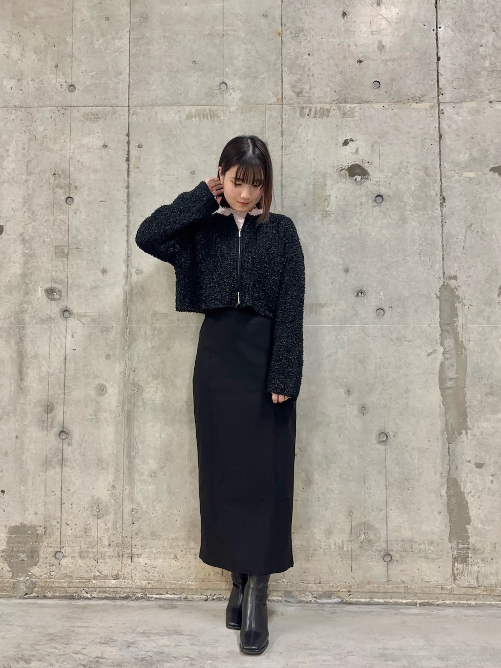 ブラック系のスカート、ピンク系のTシャツ/カットソー、ブラック系のブーツを着用したレディースの冬コーディネートの2枚目の写真