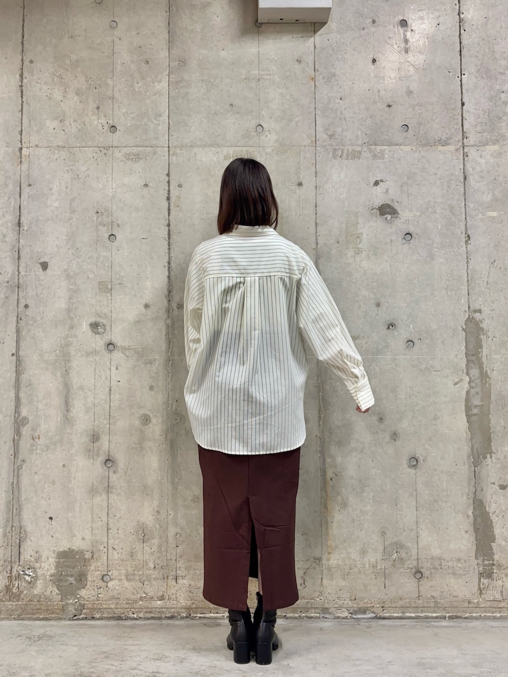 ホワイト系のシャツ/ブラウス、ホワイト系のTシャツ/カットソー、ブラック系のブーツを着用したレディースの冬コーディネートの4枚目の写真