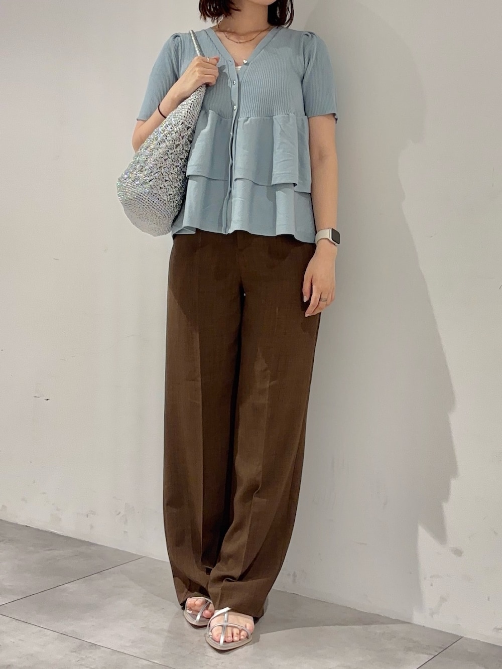 ブルー系のカーディガン/ボレロ、シルバー系のサンダル、シルバー系のかごバッグを着用したレディースの夏コーディネートの2枚目の写真