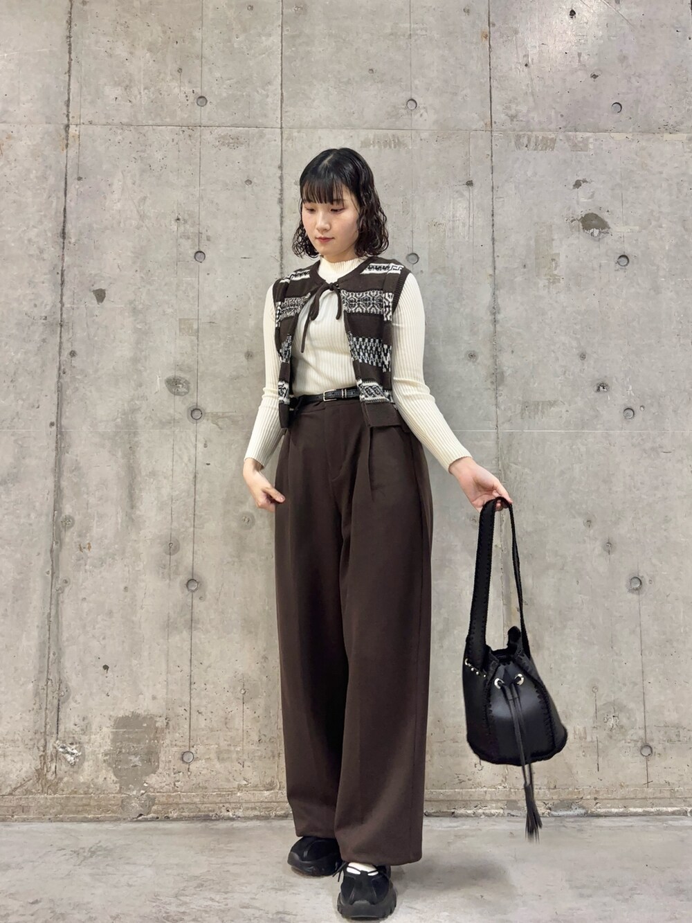 ブラウン系のその他パンツ、ブラウン系のベスト、ホワイト系のニット/セーターを着用したレディースの秋コーディネートの2枚目の写真