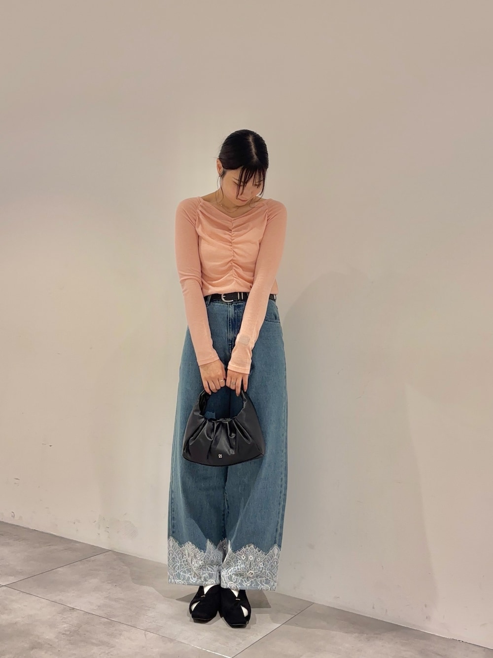 ピンク系のTシャツ/カットソー、ブラック系のハンドバッグ、ブルー系のデニムパンツを着用したレディースの夏コーディネートの2枚目の写真