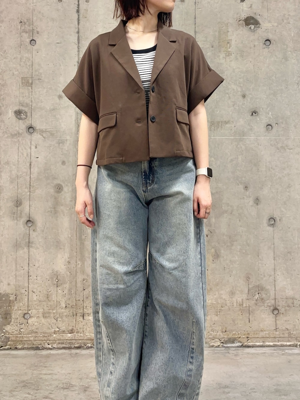ブラウン系のその他アウター、ホワイト系のTシャツ/カットソー、ブラック系のサンダルを着用したレディースの春コーディネートの2枚目の写真