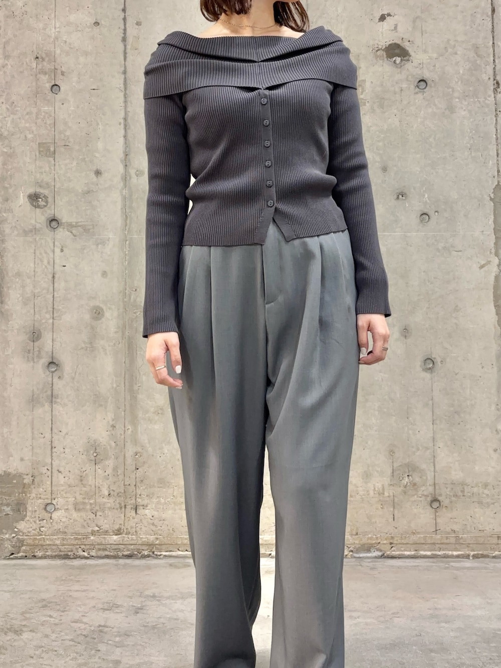 グレー系のニット/セーター、ブラウン系のローファー、グレー系のスラックスを着用したレディースの春コーディネートの3枚目の写真