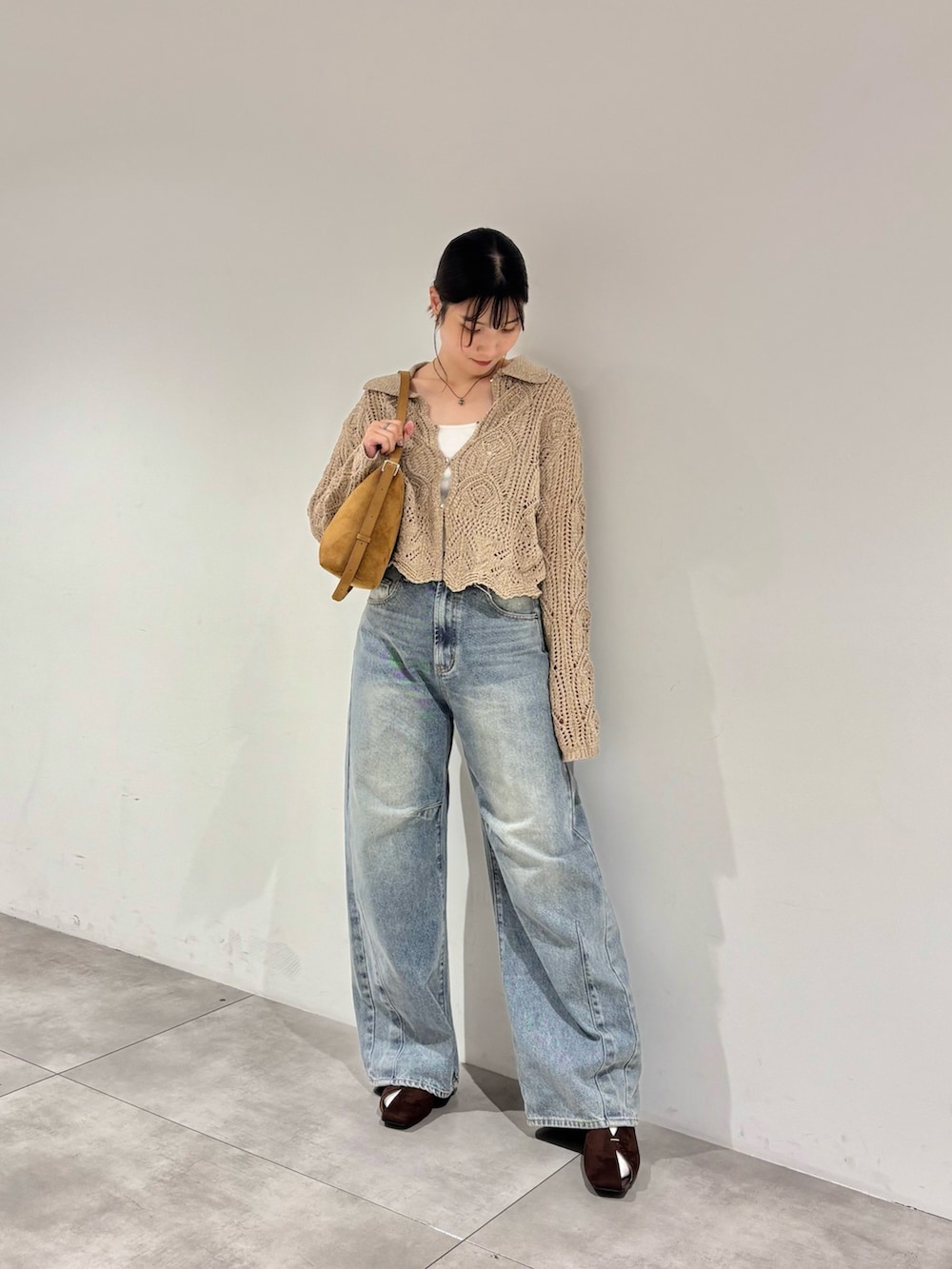 ブルー系のデニムパンツ、ブラウン系のパンプス、イエロー系のショルダーバッグを着用したレディースの秋コーディネートの2枚目の写真