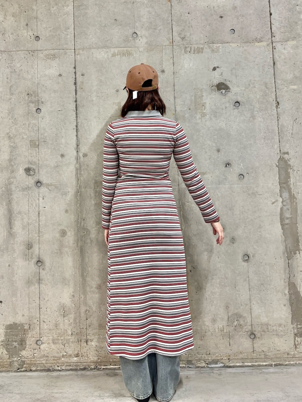 ブルー系のデニムパンツ、ブラウン系のバレエシューズ、グレー系のワンピースを着用したレディースの春コーディネートの2枚目の写真