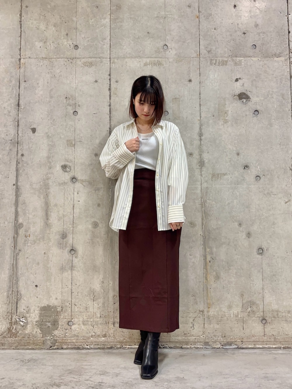 ホワイト系のシャツ/ブラウス、ホワイト系のTシャツ/カットソー、ブラック系のブーツを着用したレディースの冬コーディネートの2枚目の写真