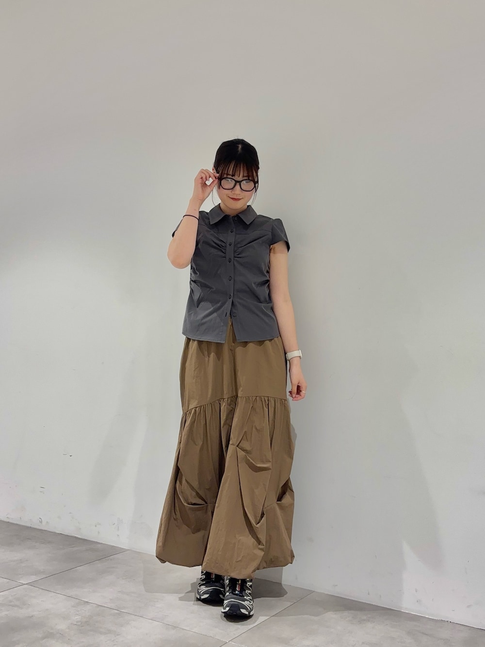 グレー系のシャツ/ブラウス、ブラウン系のスカート、グレー系のスニーカーを着用したレディースの春コーディネートの2枚目の写真