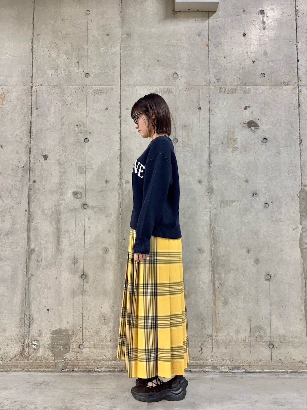 ブルー系のニット/セーター、イエロー系のスカート、ブラウン系のスニーカーを着用したレディースの冬コーディネートの3枚目の写真