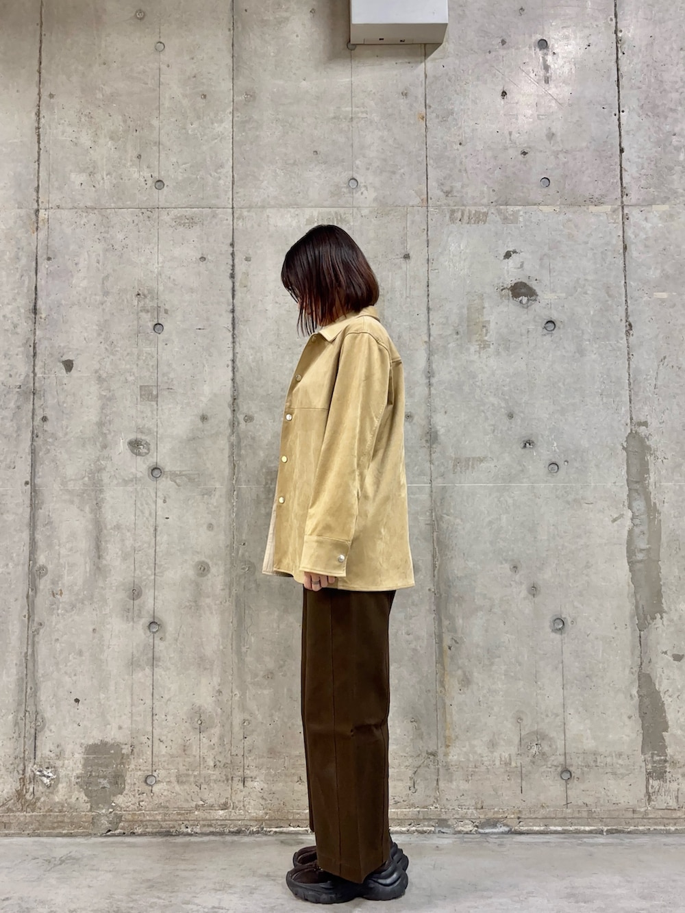 ベージュ系のその他アウター、ホワイト系のニット/セーター、ブラウン系のその他パンツを着用したレディースの冬コーディネートの2枚目の写真