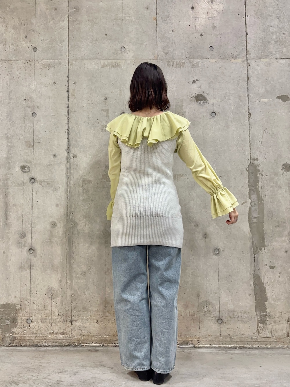 ブルー系のデニムパンツ、ブラック系のその他シューズ、ホワイト系のベストを着用したレディースの冬コーディネートの4枚目の写真