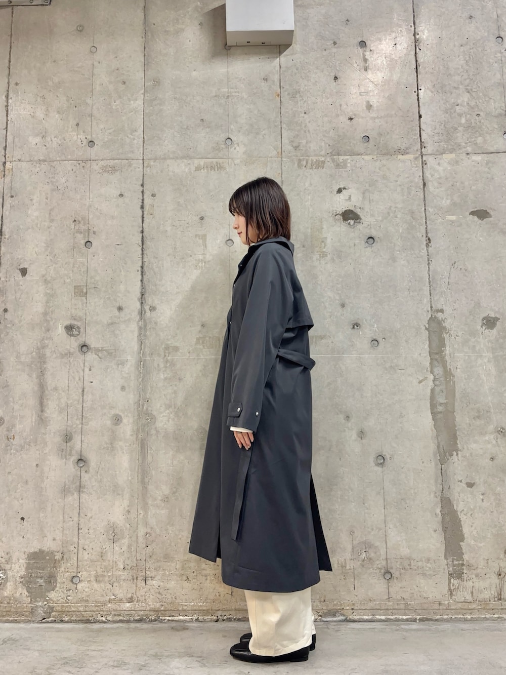 グレー系のトレンチコート、ホワイト系のTシャツ/カットソー、ホワイト系のその他パンツを着用したレディースの冬コーディネートの3枚目の写真