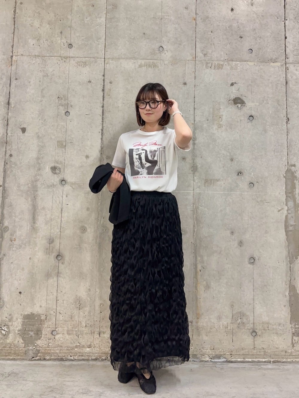 ブラック系のスカート、ブラック系のその他アウター、その他のTシャツ/カットソーを着用したレディースの春コーディネートの2枚目の写真