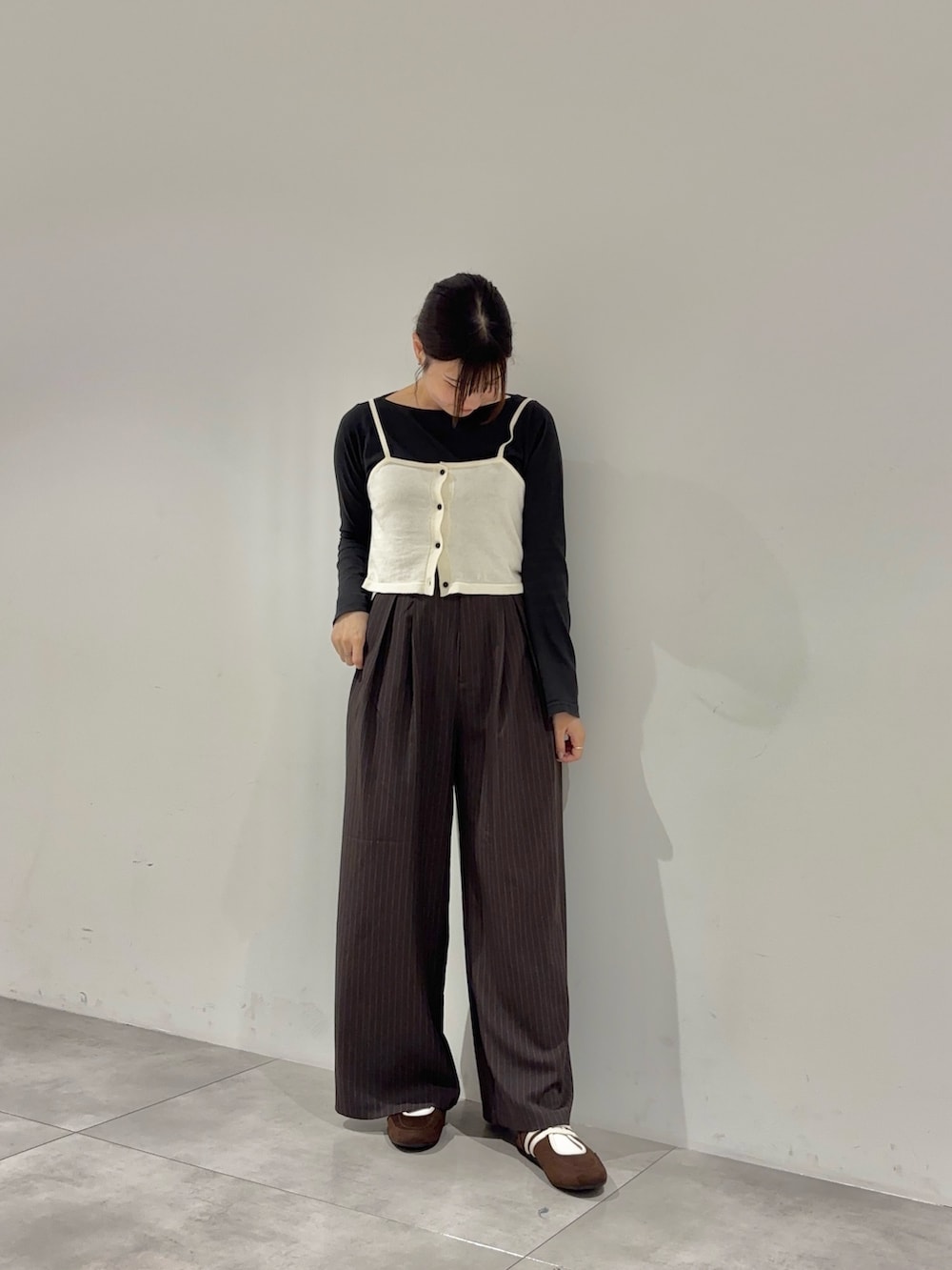 ブラック系のTシャツ/カットソー、ホワイト系のニット/セーター、ブラウン系のスラックスを着用したレディースの夏コーディネートの2枚目の写真