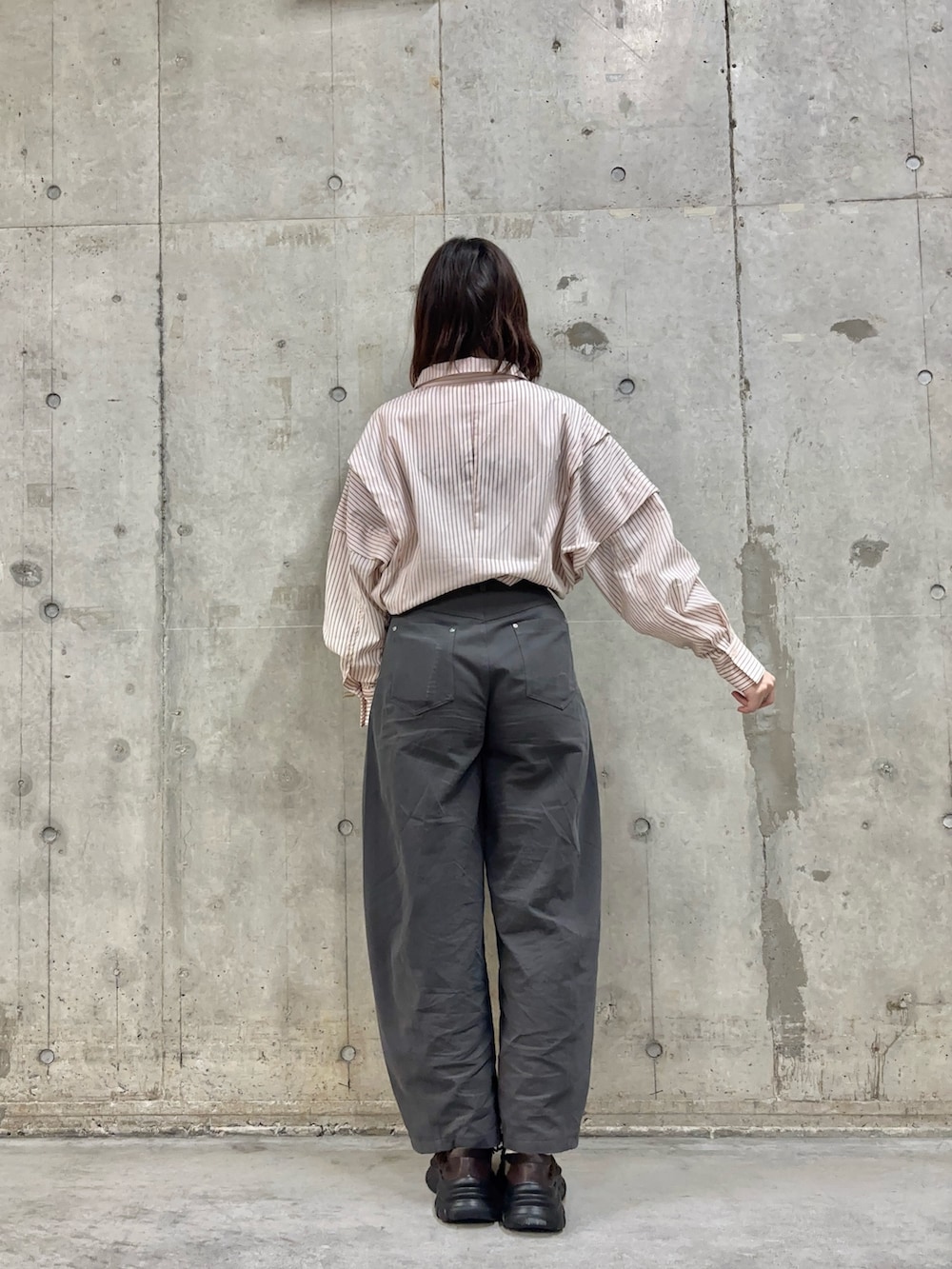 グレー系のその他パンツ、ブラウン系のスニーカー、ピンク系のシャツ/ブラウスを着用したレディースの冬コーディネートの3枚目の写真