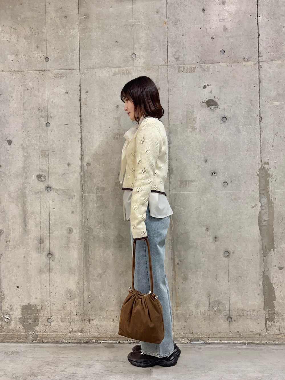 ブルー系のデニムパンツ、ホワイト系のシャツ/ブラウス、ホワイト系のカーディガン/ボレロを着用したレディースの冬コーディネートの3枚目の写真