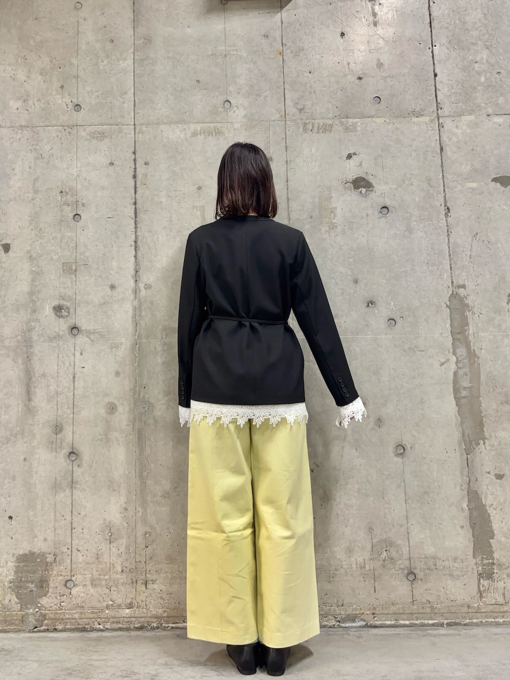 ブラック系のノーカラージャケット、ホワイト系のTシャツ/カットソー、イエロー系のその他パンツを着用したレディースの春コーディネートの4枚目の写真