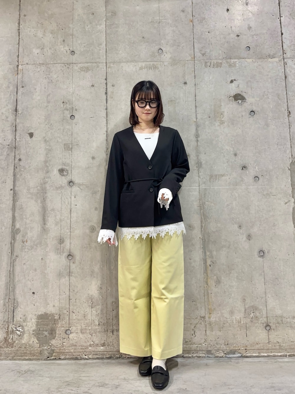 ブラック系のノーカラージャケット、ホワイト系のTシャツ/カットソー、イエロー系のその他パンツを着用したレディースの春コーディネートの2枚目の写真