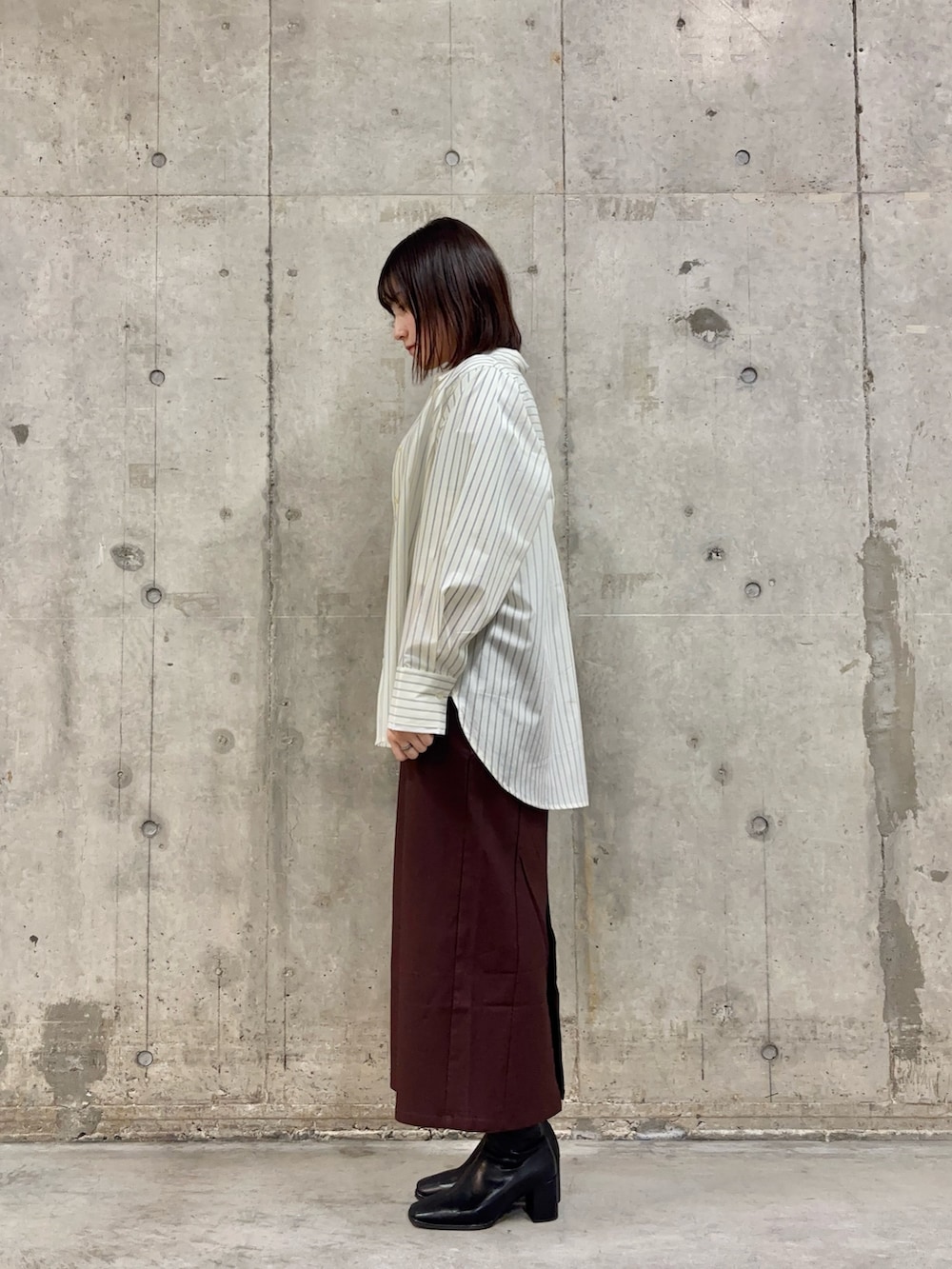 ホワイト系のシャツ/ブラウス、ホワイト系のTシャツ/カットソー、ブラック系のブーツを着用したレディースの冬コーディネートの3枚目の写真