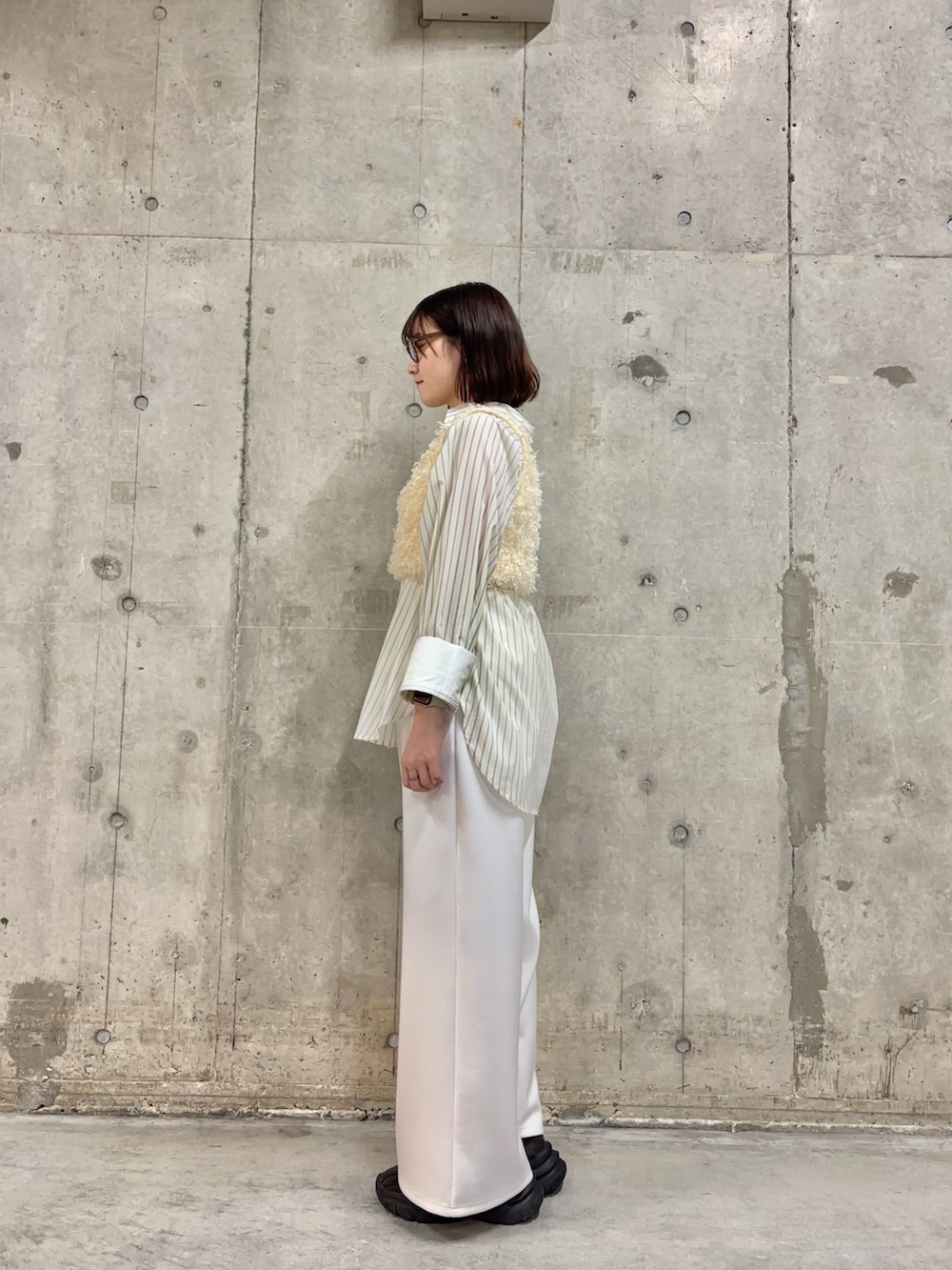 ホワイト系のベスト、ホワイト系のシャツ/ブラウス、ブラウン系のスニーカーを着用したレディースの春コーディネートの3枚目の写真