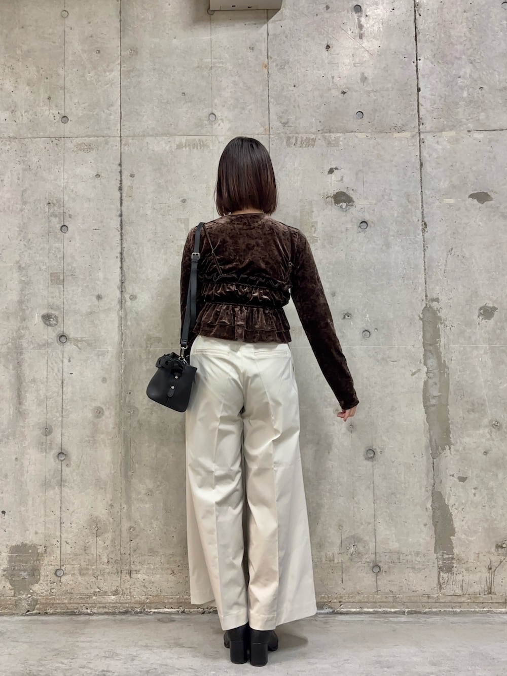 ブラック系のブーツ、ホワイト系のチノパンツ、ブラウン系のTシャツ/カットソーを着用したレディースの冬コーディネートの3枚目の写真