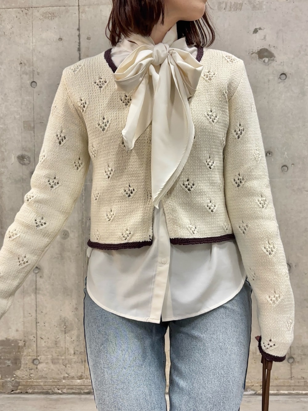 ブルー系のデニムパンツ、ホワイト系のシャツ/ブラウス、ホワイト系のカーディガン/ボレロを着用したレディースの冬コーディネートの2枚目の写真