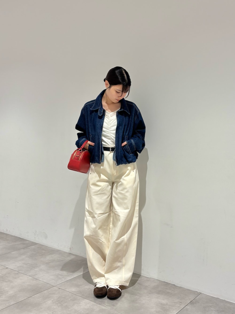 ブラウン系のスニーカー、ホワイト系のその他パンツ、レッド系のショルダーバッグを着用したレディースの秋コーディネートの3枚目の写真