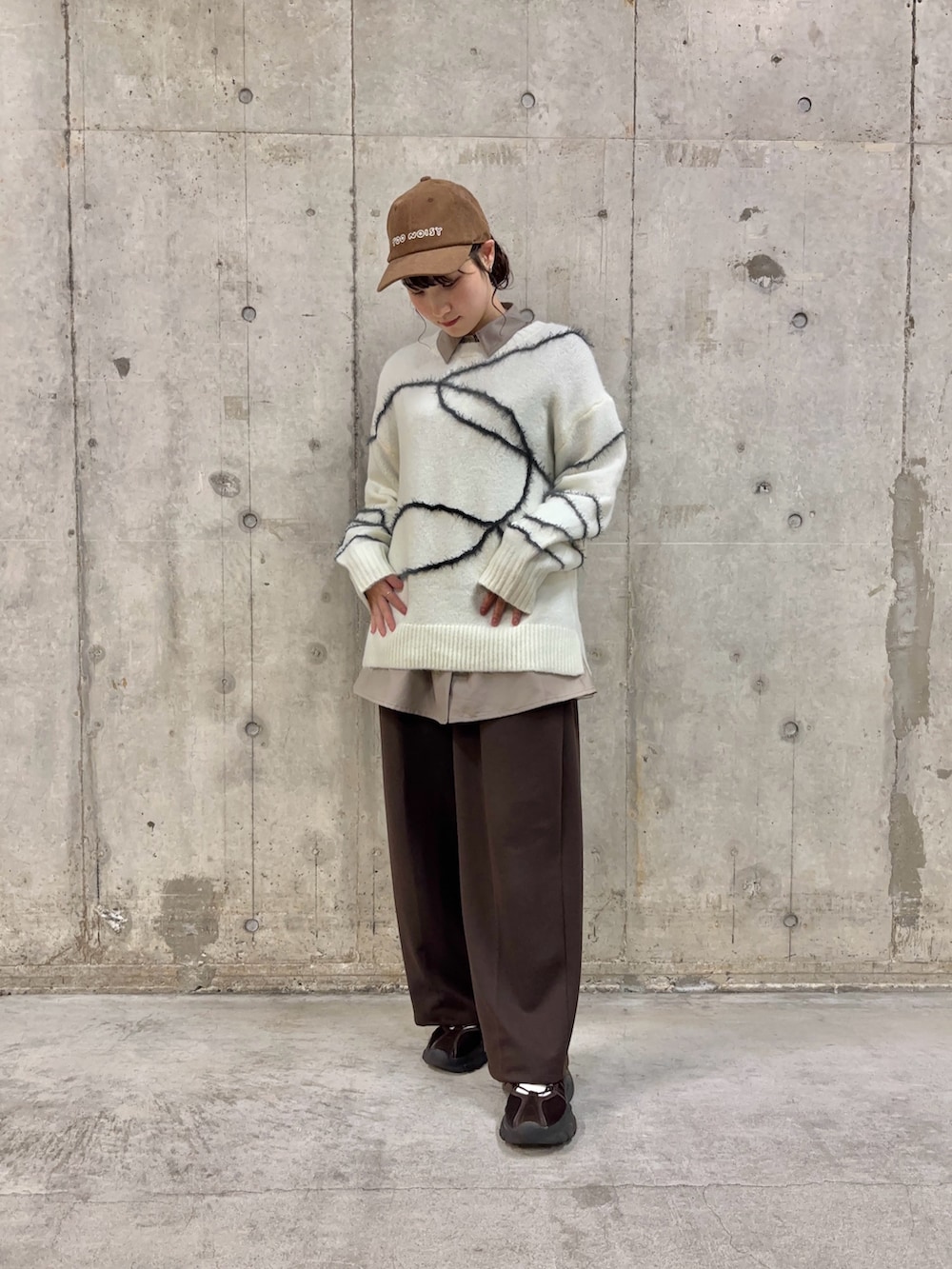 ブラウン系のシャツ/ブラウス、ホワイト系のニット/セーター、ブラウン系のスラックスを着用したレディースの冬コーディネートの2枚目の写真