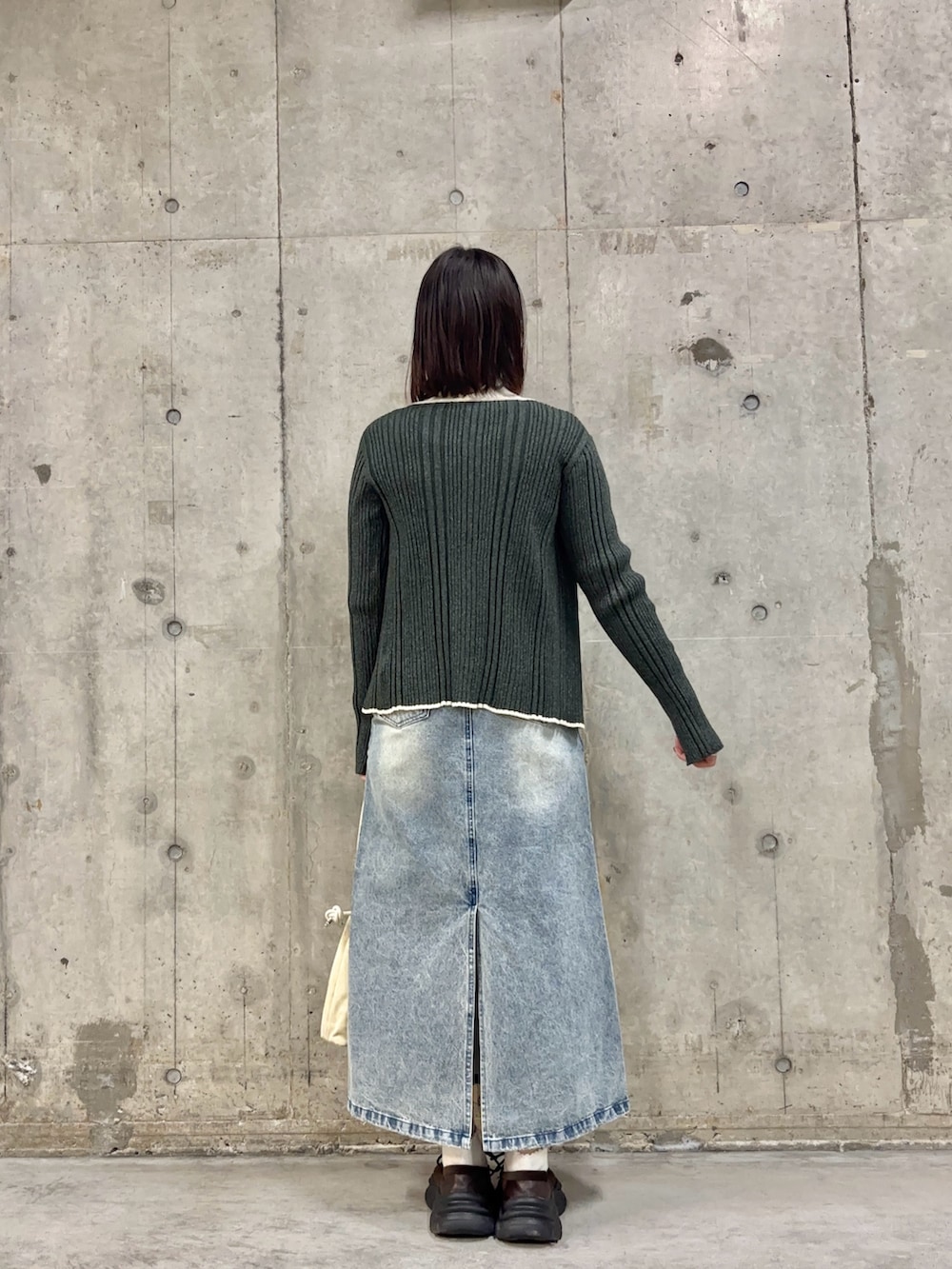 ブルー系のスカート、ホワイト系のニット/セーター、グレー系のニット/セーターを着用したレディースの冬コーディネートの3枚目の写真