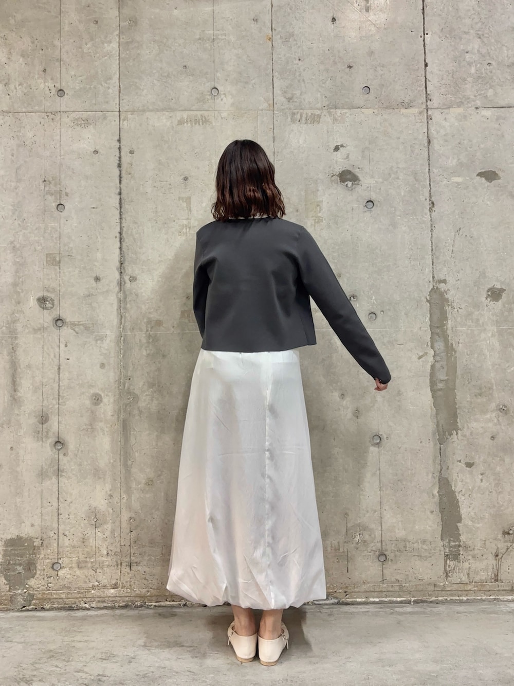 ホワイト系のシャツ/ブラウス、グレー系のニット/セーター、ホワイト系のスカートを着用したレディースの春コーディネートの4枚目の写真