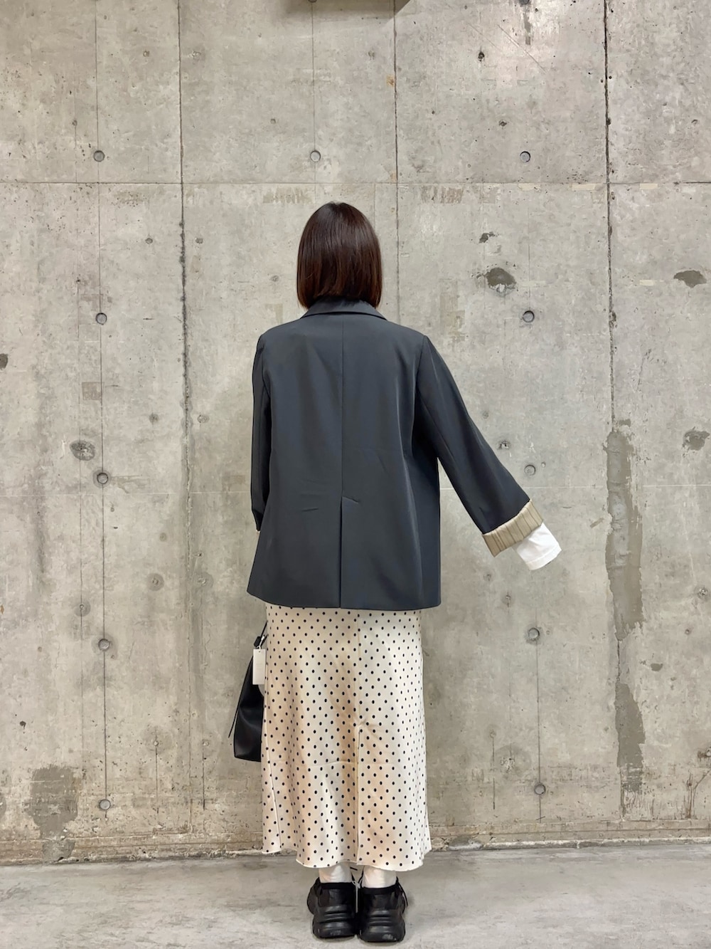 グレー系のテーラードジャケット、ホワイト系のTシャツ/カットソー、ホワイト系のスカートを着用したレディースの春コーディネートの4枚目の写真