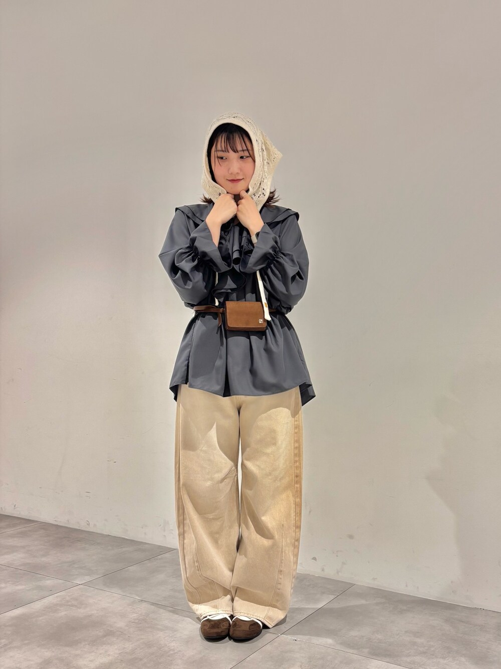 ベージュ系のデニムパンツ、グレー系のワンピース、ブラウン系のスニーカーを着用したレディースの秋コーディネートの2枚目の写真