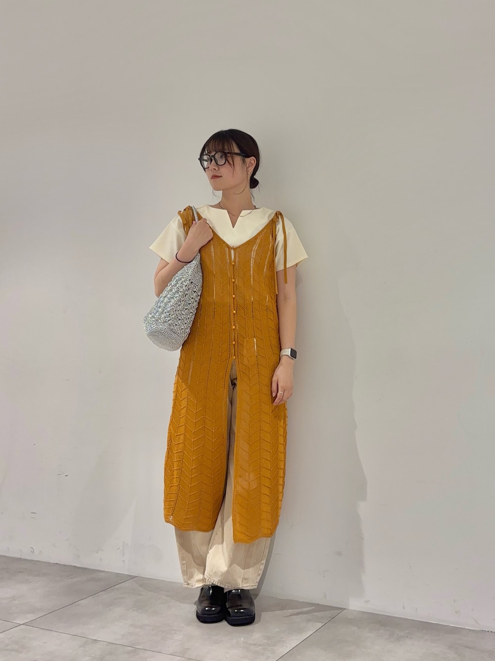 ホワイト系のTシャツ/カットソー、オレンジ系のワンピース、ベージュ系のデニムパンツを着用したレディースの春コーディネートの2枚目の写真