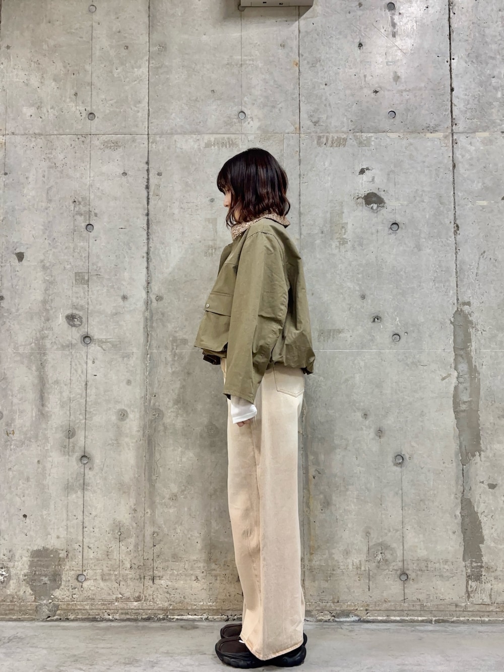 ベージュ系のデニムパンツ、グリーン系のブルゾン、ホワイト系のシャツ/ブラウスを着用したレディースの冬コーディネートの3枚目の写真