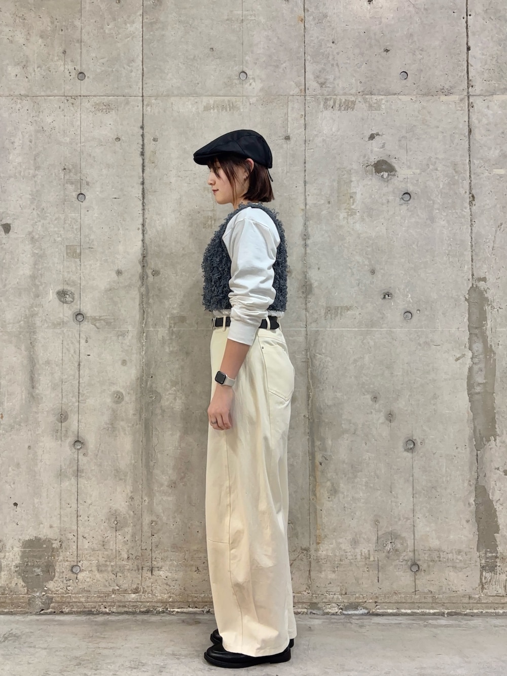 ブラック系のローファー、ホワイト系のその他パンツ、グレー系のベストを着用したレディースの春コーディネートの3枚目の写真