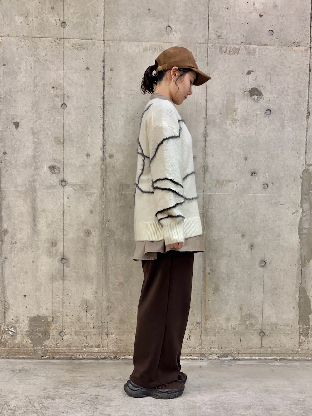 ブラウン系のシャツ/ブラウス、ホワイト系のニット/セーター、ブラウン系のスラックスを着用したレディースの冬コーディネートの3枚目の写真