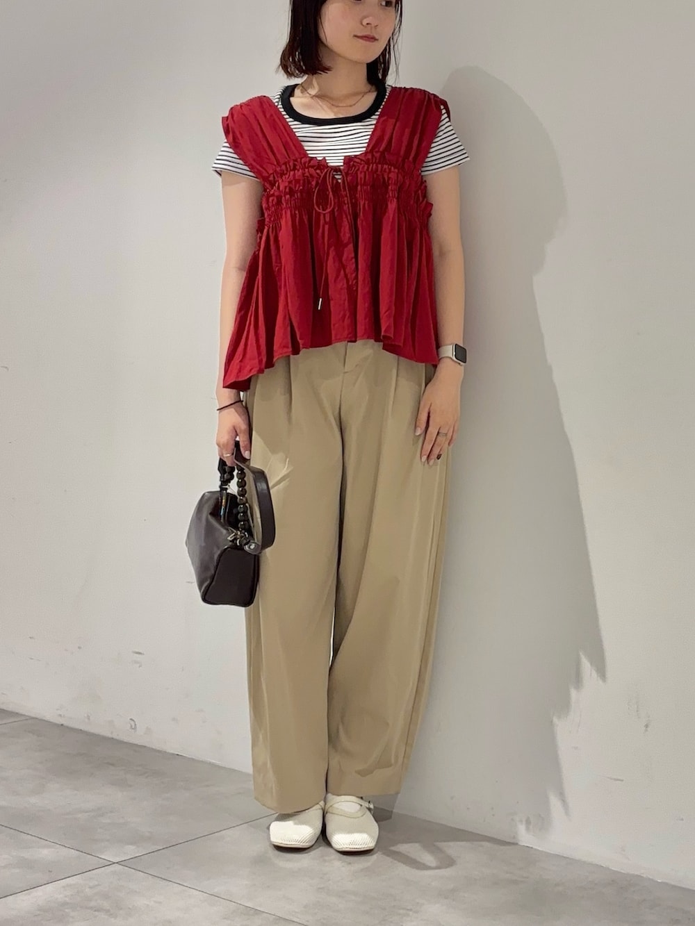 レッド系のシャツ/ブラウス、ホワイト系のTシャツ/カットソー、ベージュ系のその他パンツを着用したレディースの夏コーディネートの2枚目の写真