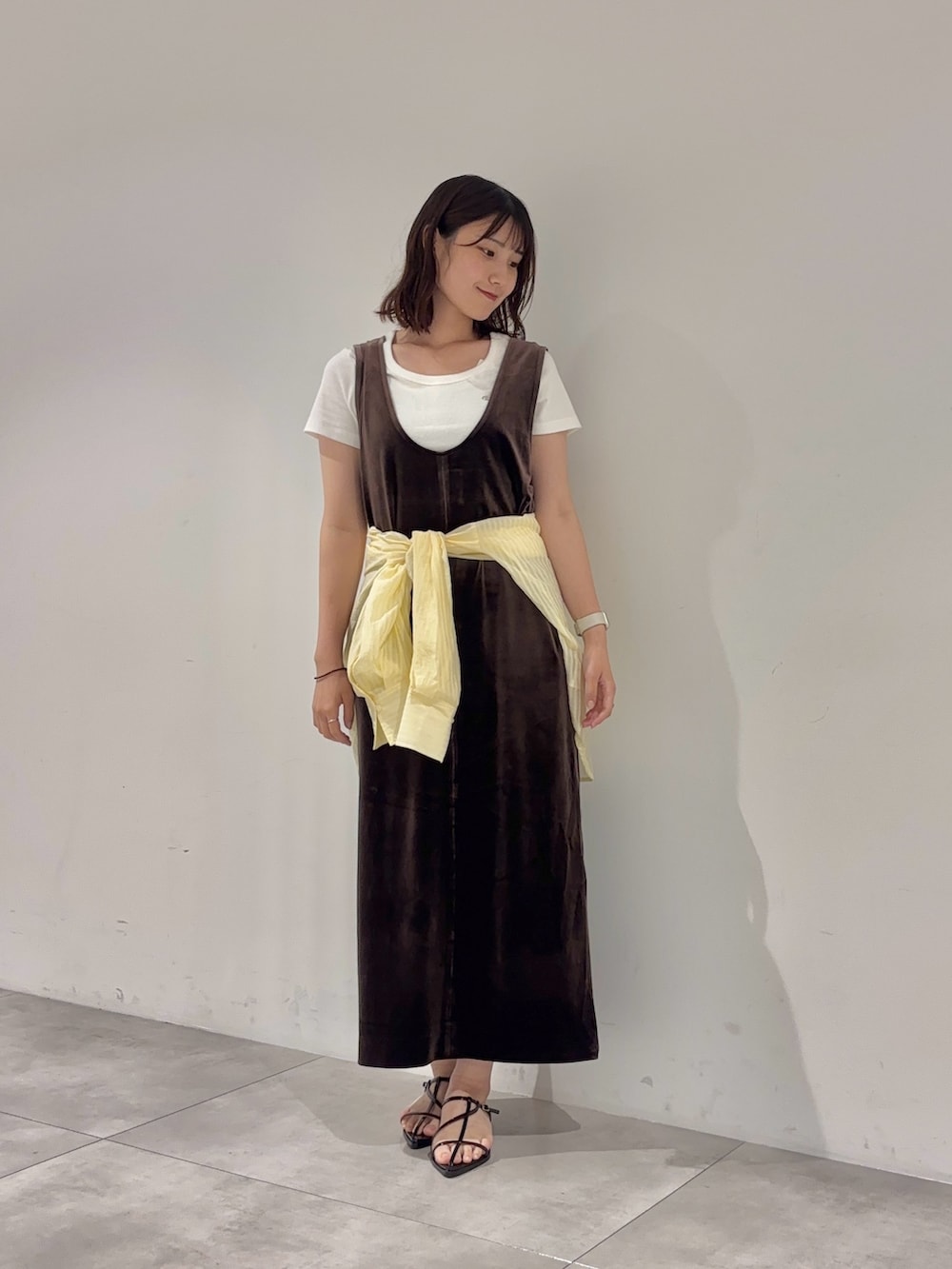 ブラウン系のワンピース、ホワイト系のTシャツ/カットソー、イエロー系のシャツ/ブラウスを着用したレディースの夏コーディネートの2枚目の写真