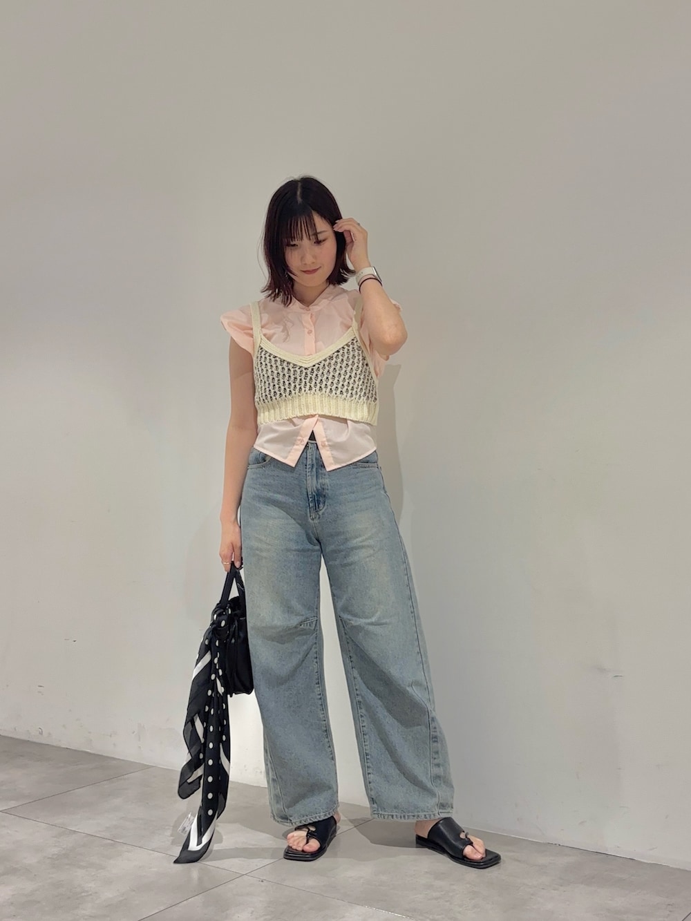 ブラック系のショルダーバッグ、ピンク系のシャツ/ブラウス、ホワイト系のニット/セーターを着用したレディースの夏コーディネートの2枚目の写真