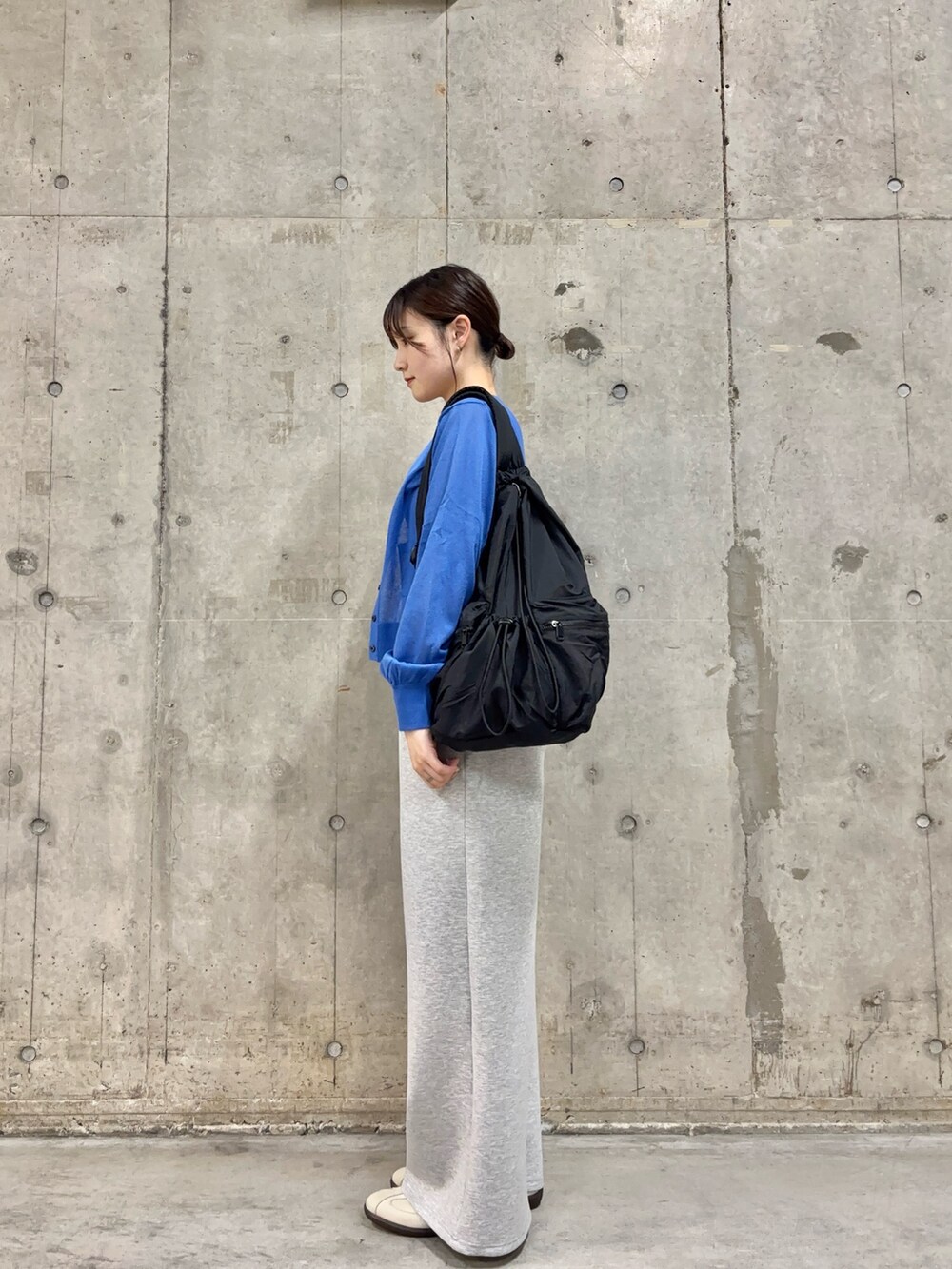 ブルー系のカーディガン/ボレロ、ホワイト系のスニーカー、ブラック系のバックパック/リュックを着用したレディースの春コーディネートの3枚目の写真