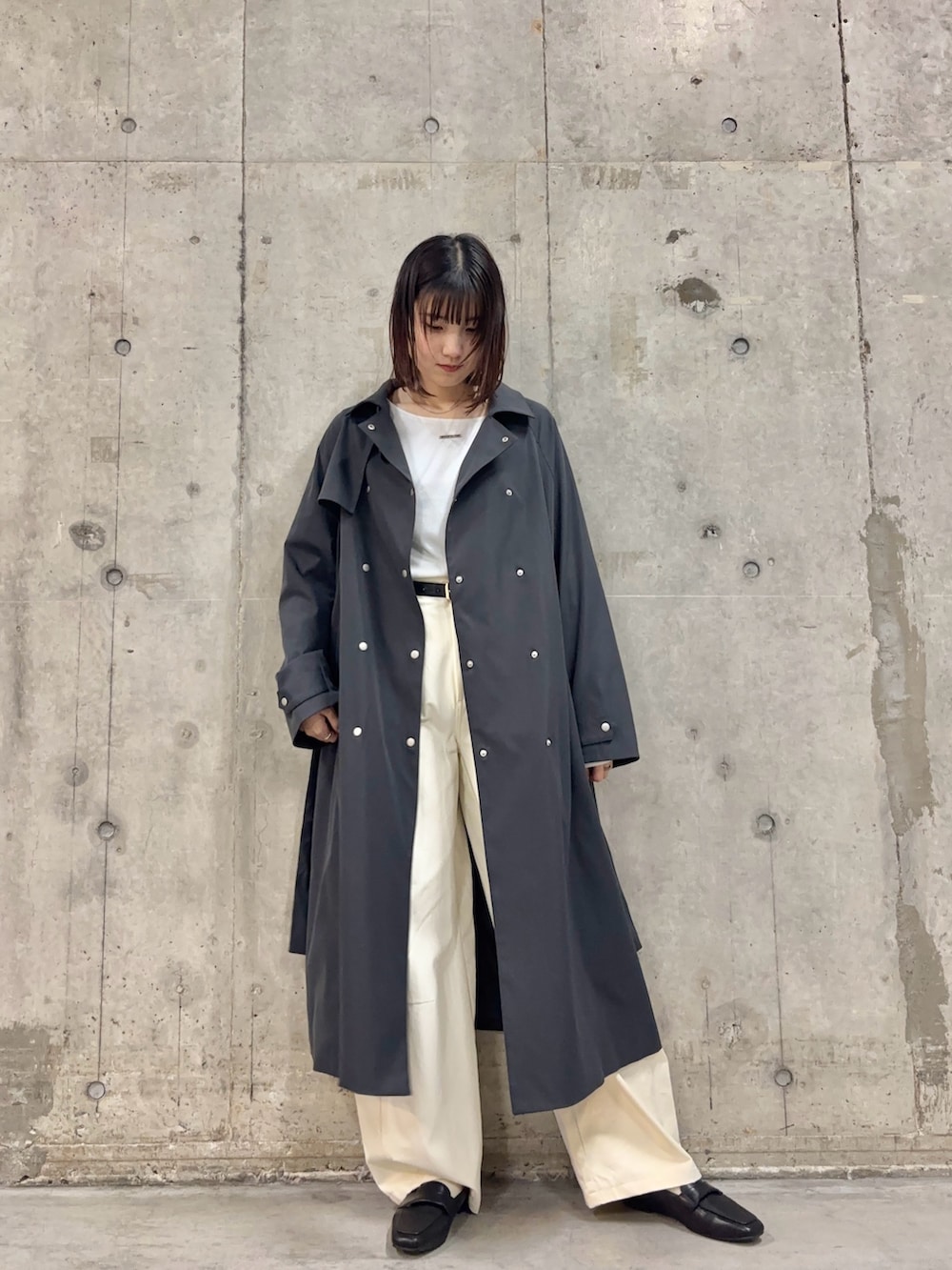 グレー系のトレンチコート、ホワイト系のTシャツ/カットソー、ホワイト系のその他パンツを着用したレディースの冬コーディネートの2枚目の写真