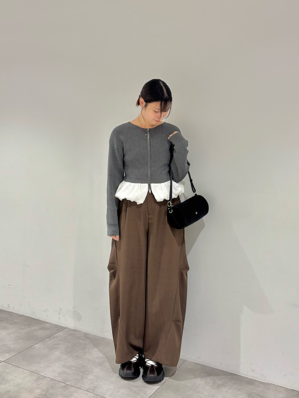 グレー系のカーディガン/ボレロ、ブラウン系のその他パンツ、ブラウン系のスニーカーを着用したレディースの秋コーディネートの2枚目の写真