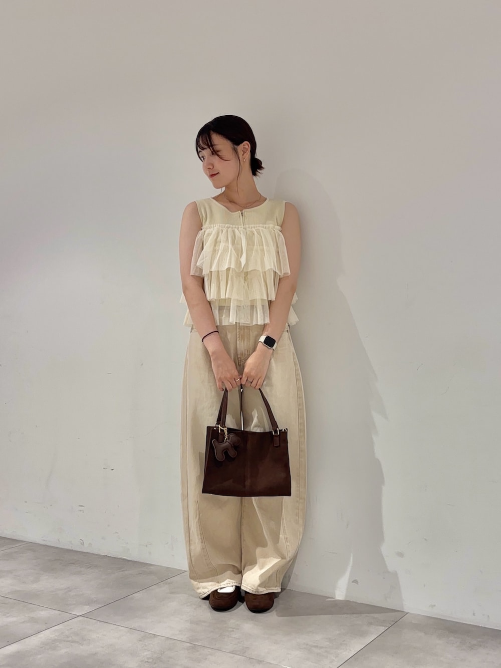 ベージュ系のデニムパンツ、ホワイト系のニット/セーター、ブラウン系のバレエシューズを着用したレディースの夏コーディネートの2枚目の写真